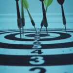 Close-up view of darts hitting a bullseye on a target board, symbolizing precision and focus.